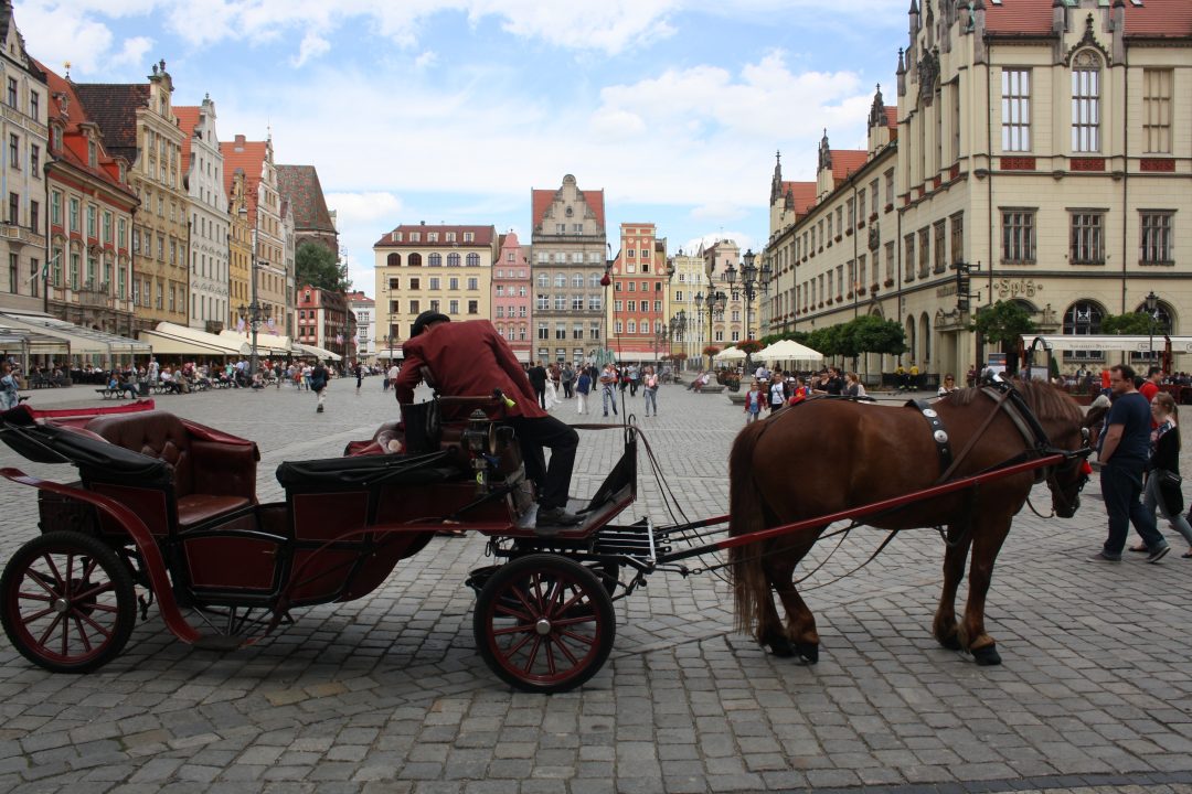Every Picture Tells a Story: A man adjusts his cart in the Stary Miasto, Wrocław