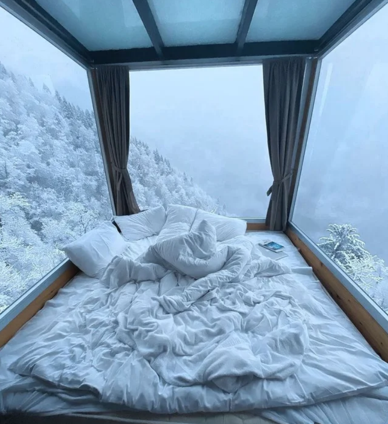 This cosy bed view that overlooks a snowy wilderness
