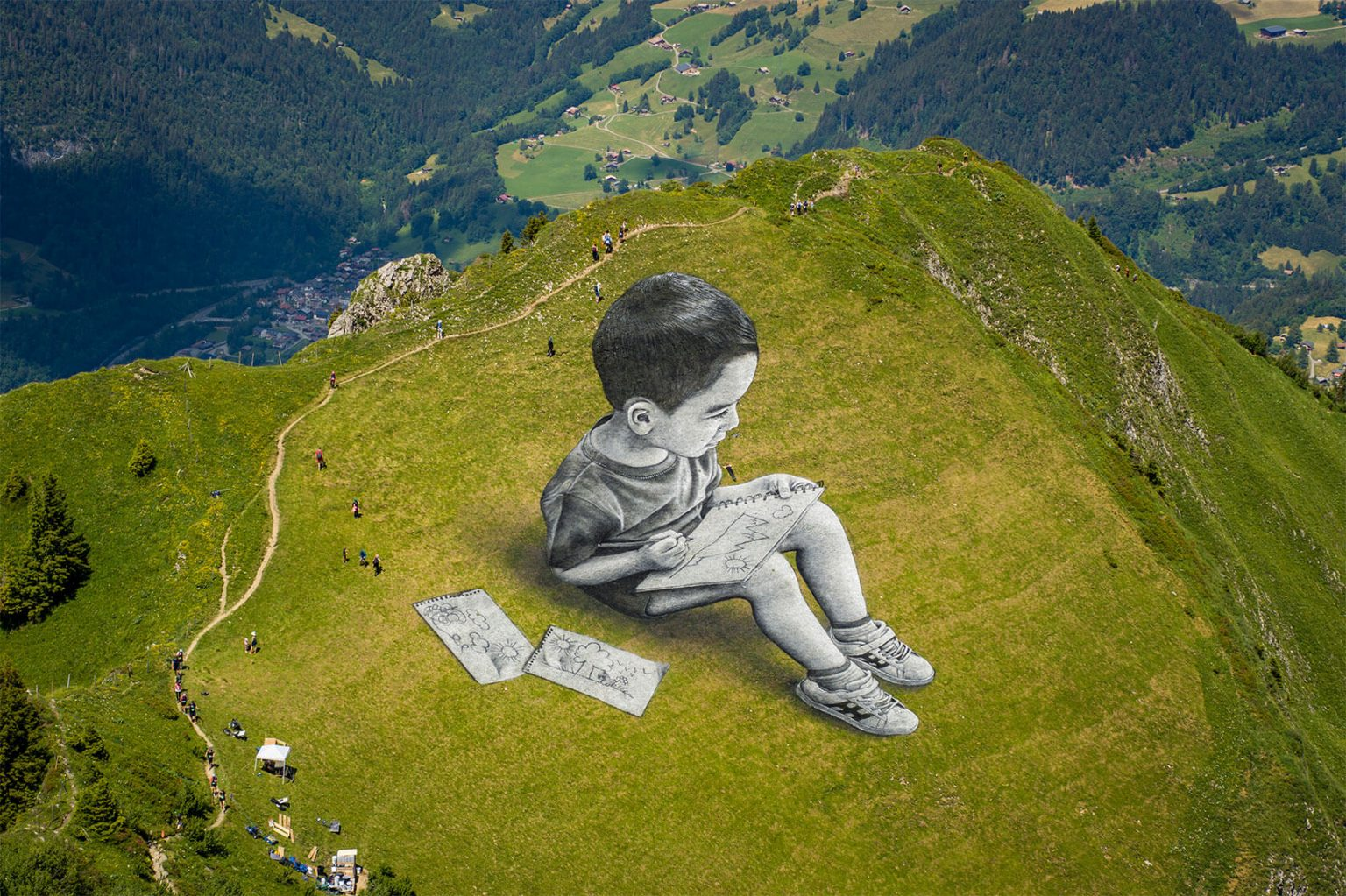 Gargantuan children on top of mountains by street artist Saype 